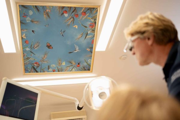 Dr. André Kruse im Behandlungszimmer mit Dekoelementen an der Decke